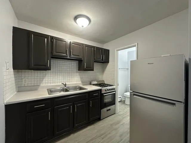 a kitchen with stainless steel appliances a refrigerator sink and cabinets