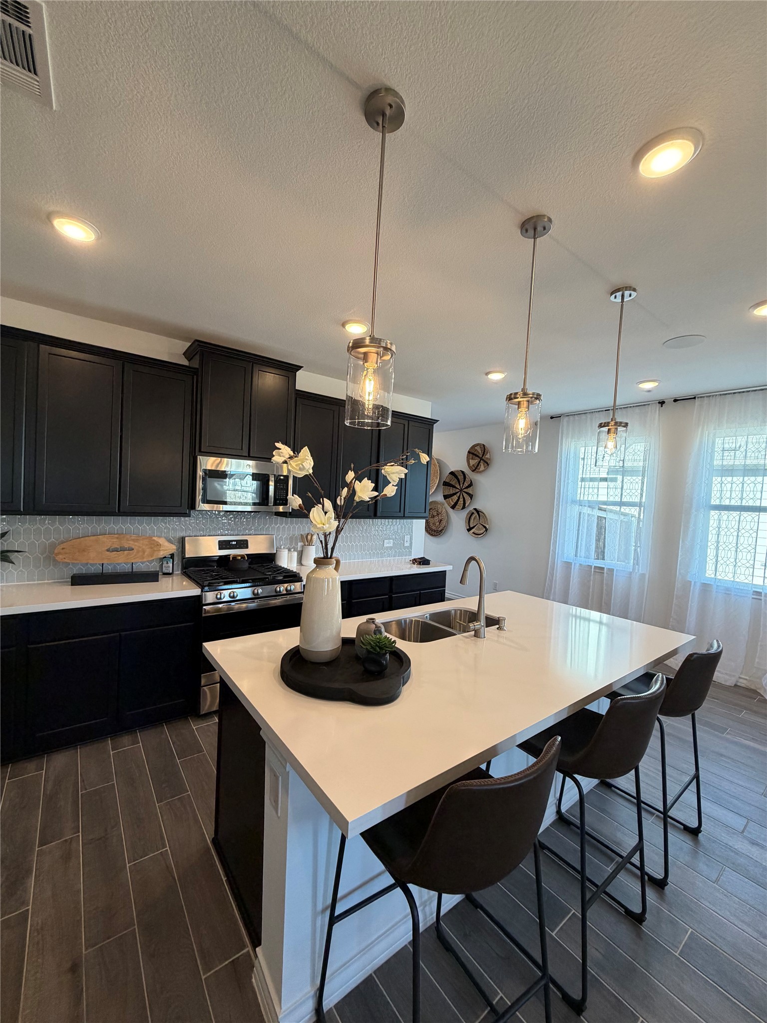 306 Stinchcomb Road Hutto, TX 78634 - Photo 4 of 19 a kitchen with kitchen island a stove a table and chairs in it