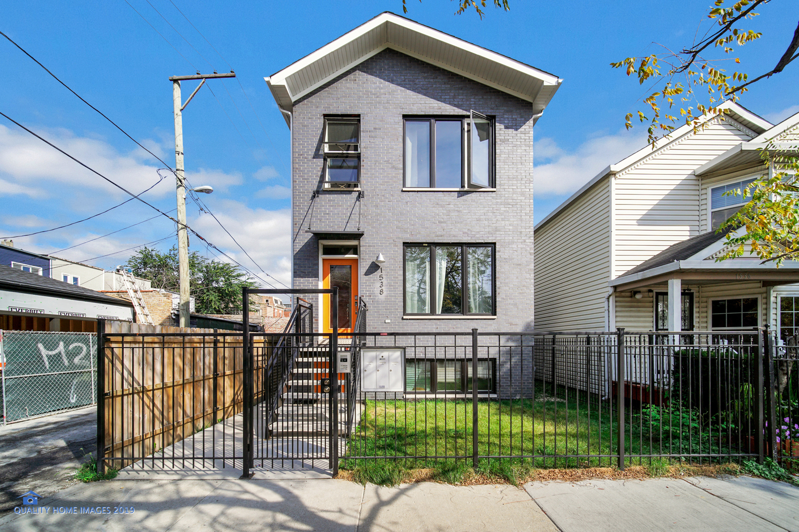 a view of a white house with iron fence