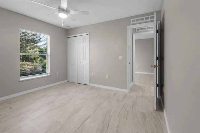 an empty room with windows and closet