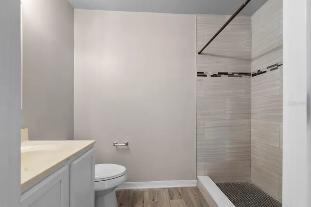 a bathroom with a granite countertop sink toilet and shower