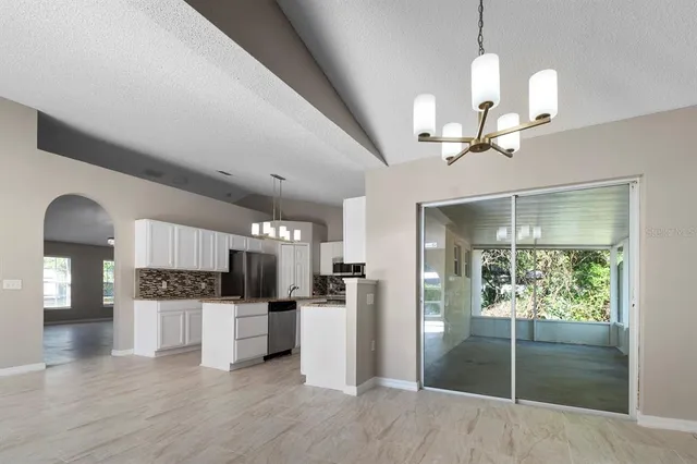 a kitchen with stainless steel appliances kitchen island granite countertop a refrigerator and a sink