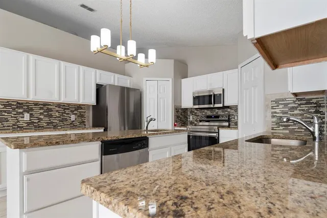 a kitchen with stainless steel appliances a stove sink microwave and cabinets
