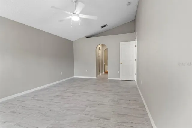 a view of an empty room with a ceiling fan