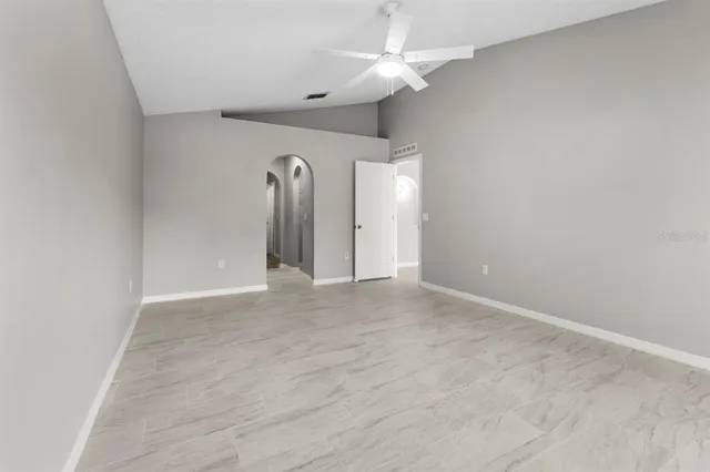 an empty room with a chandelier fan and closet
