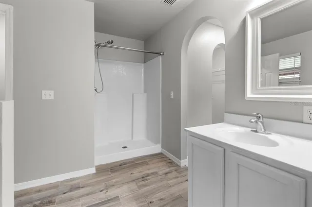 a bathroom with a sink a toilet and shower