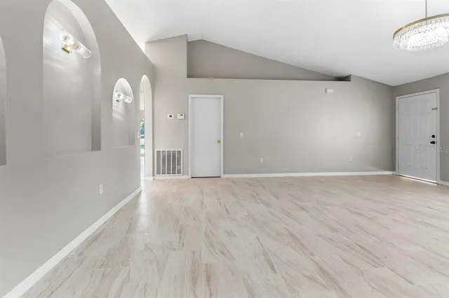 a view of empty room with wooden floor