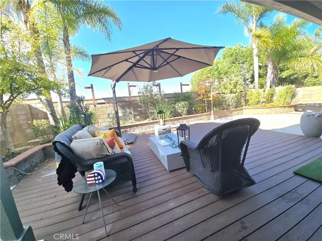 a view of patio with table and chairs under an umbrella with wooden floor
