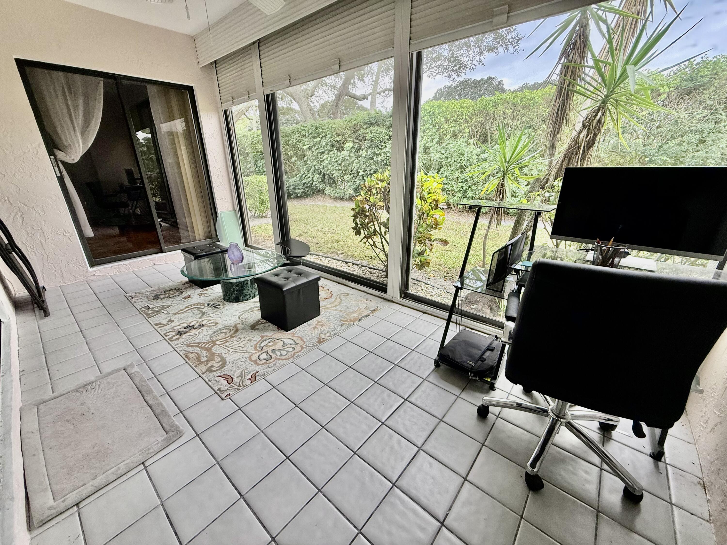 10980 Hidden Lake Place Boca Raton, FL 33498 - Photo 24 of 47 a living room with patio furniture and a flat screen tv