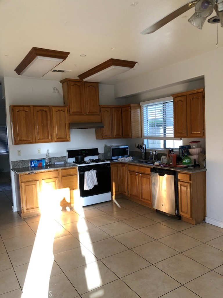 319 Lampman Way Placentia, CA 92870 - Photo 2 of 19 a kitchen with granite countertop a stove a sink and a microwave
