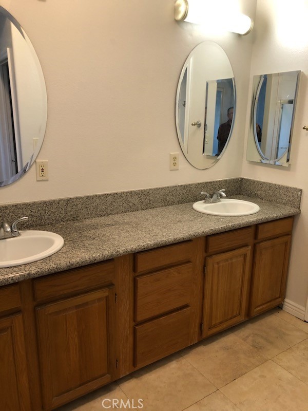 319 Lampman Way Placentia, CA 92870 - Photo 4 of 19 a bathroom with a granite countertop double vanity sink and a mirror
