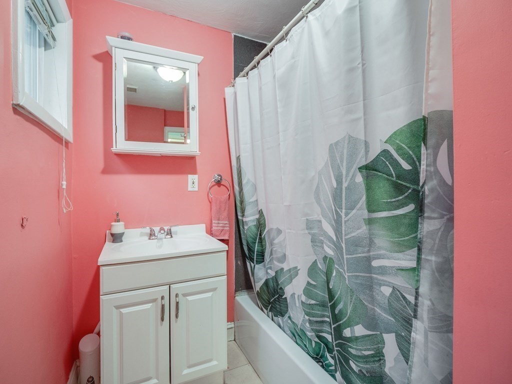 48 Chestnut Street Chelsea, MA 02150 - Photo 14 of 42 a bathroom with a sink a mirror and a shower curtain