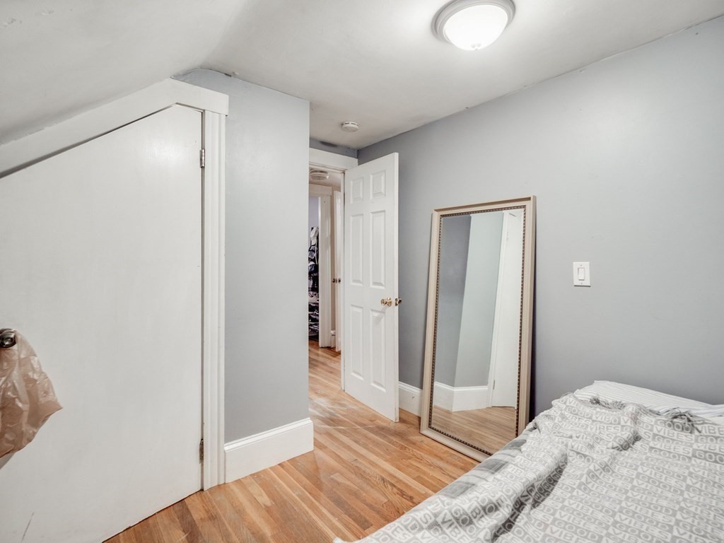 48 Chestnut Street Chelsea, MA 02150 - Photo 23 of 42 a bedroom with a bed and wooden floor
