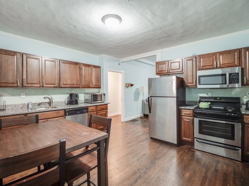 48 Chestnut Street Chelsea, MA 02150 - Photo 6 of 42 a kitchen with stainless steel appliances granite countertop a refrigerator stove microwave and sink