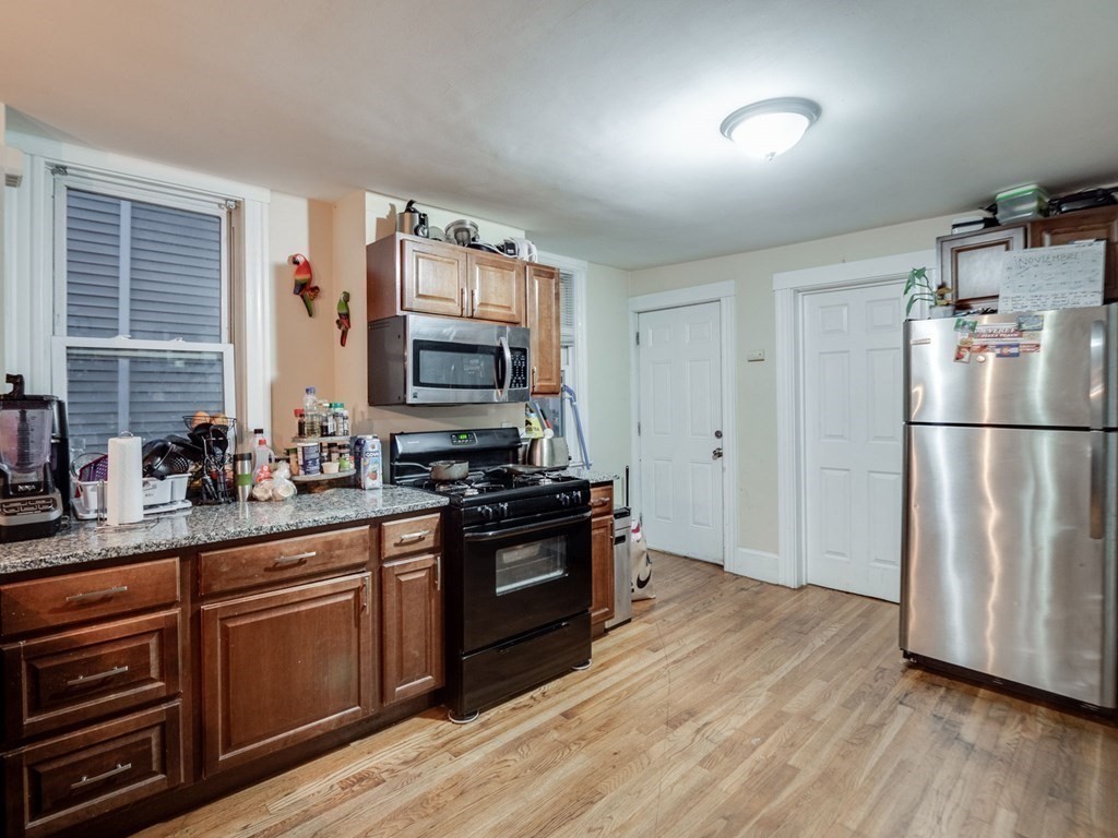 48 Chestnut Street Chelsea, MA 02150 - Photo 7 of 42 a kitchen with stainless steel appliances granite countertop a refrigerator a stove top oven a sink and dishwasher
