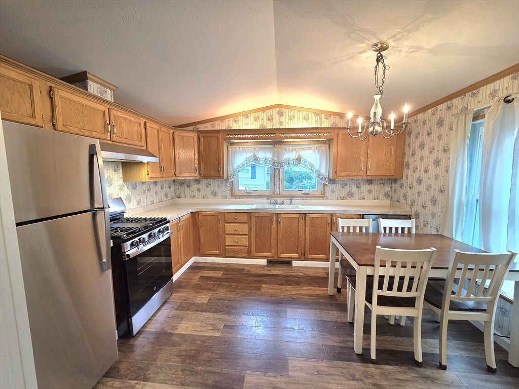 268 Palmer Road, Unit 27 Monson, MA 01057 - Photo 10 of 26 a kitchen with granite countertop a refrigerator stove a sink and dining table