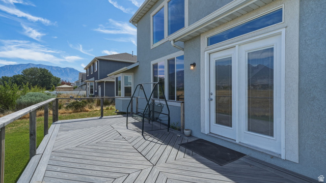 111 East Silver Oak Road Vineyard, UT 84059 - Photo 36 of 50 Spacious wood-finish deck with railing, featuring double glass doors with transom window, and a stucco exterior