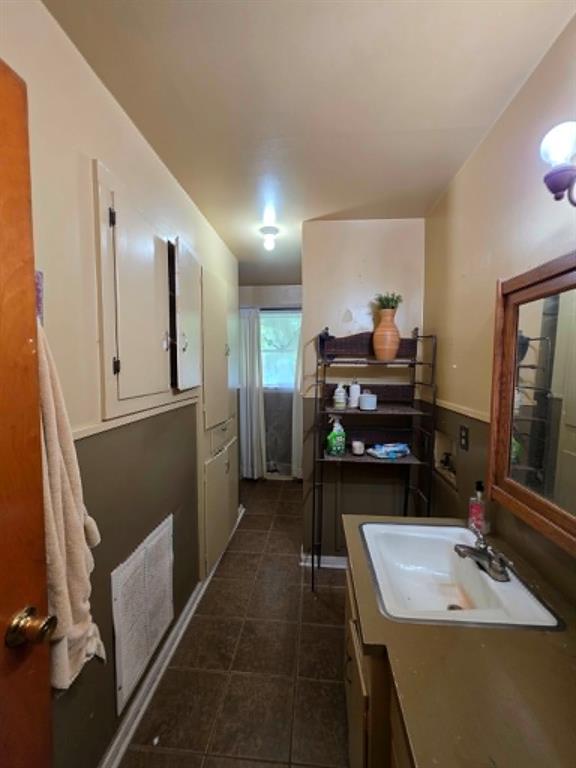 4514 West Loop 281 Longview, TX 75604 - Photo 28 of 36 Utility room featuring tiled flooring, a built-in sink with countertop, wall-mounted cabinetry, and a window