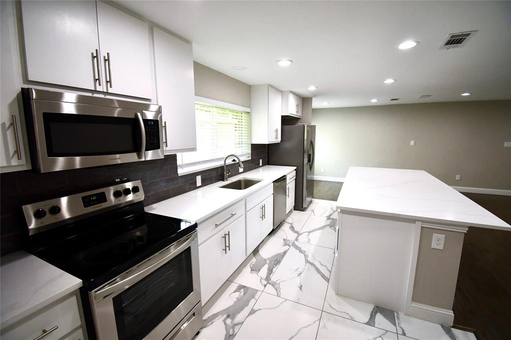 a kitchen with a sink stainless steel appliances and furniture