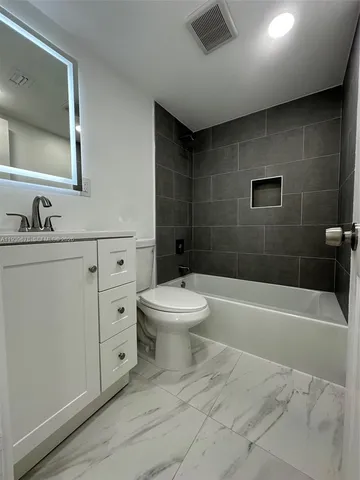 a kitchen with a sink a refrigerator and cabinets