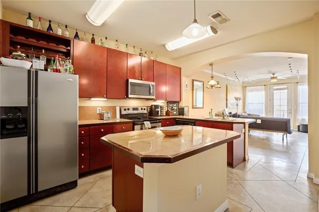a kitchen with stainless steel appliances granite countertop a sink a stove and a refrigerator