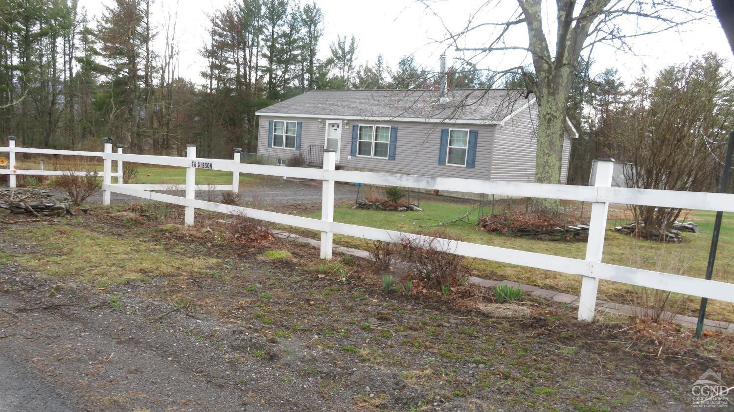 76 Gibson Road Durham, NY 12083 - Photo 1 of 22 a backyard of a house with lawn chairs and wooden fence
