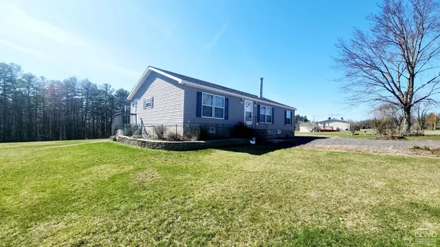 a view of a house with a yard covered in snow