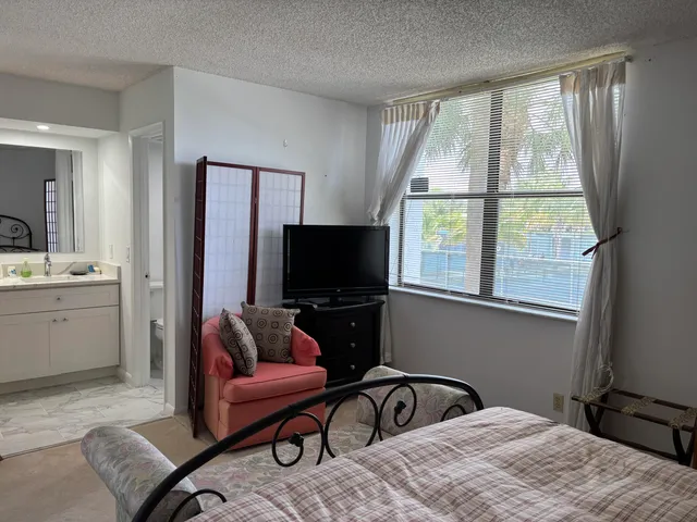 a bedroom with furniture and a flat screen tv