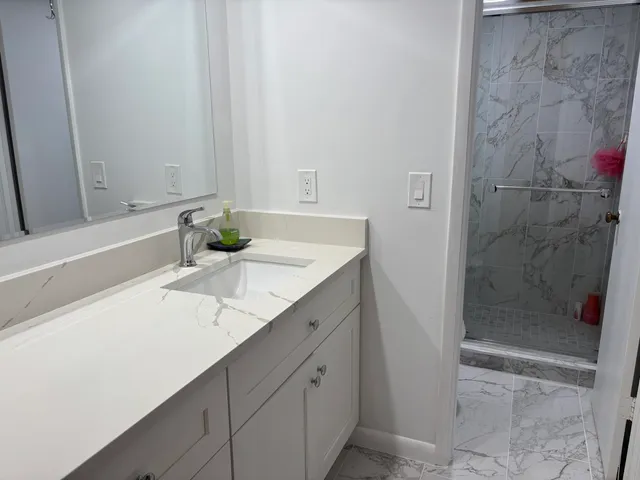 a bathroom with a granite countertop sink and a mirror