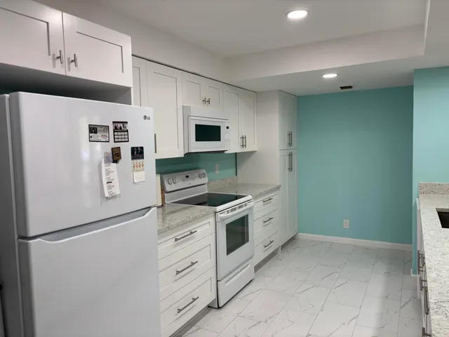 a white refrigerator freezer sitting inside of a kitchen