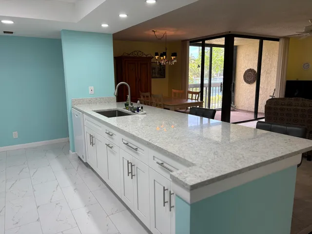 a kitchen with sink and mirror