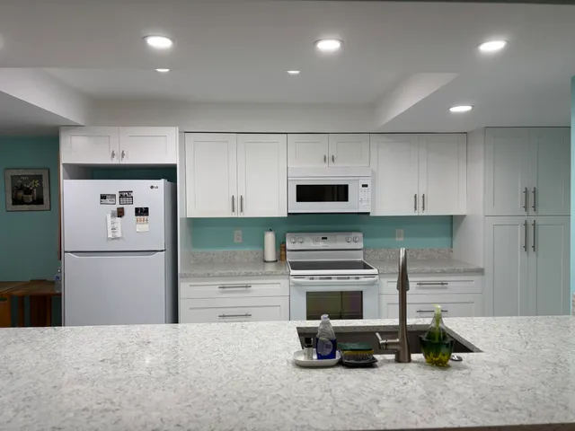 a kitchen with kitchen island a stove and a refrigerator