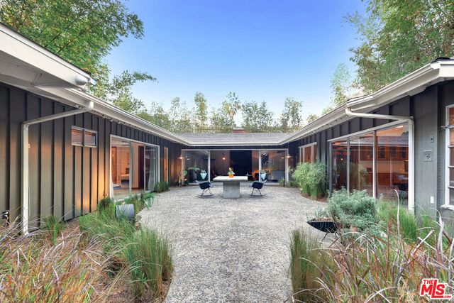 a view of a house with backyard sitting area and garden