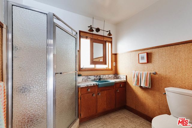 a bathroom with a granite countertop toilet sink and mirror