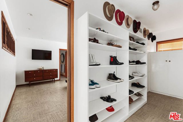 a view of walk in closet with clothes and shoes