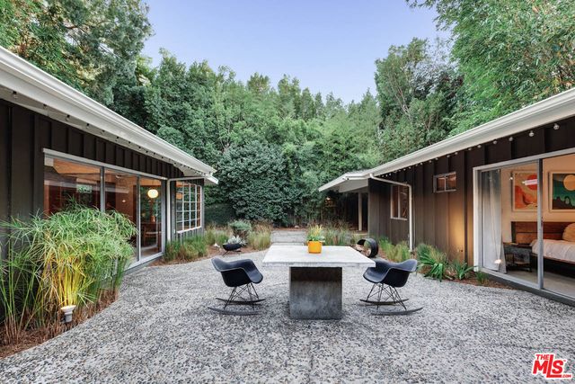 a view of a patio with table and chairs and potted plants