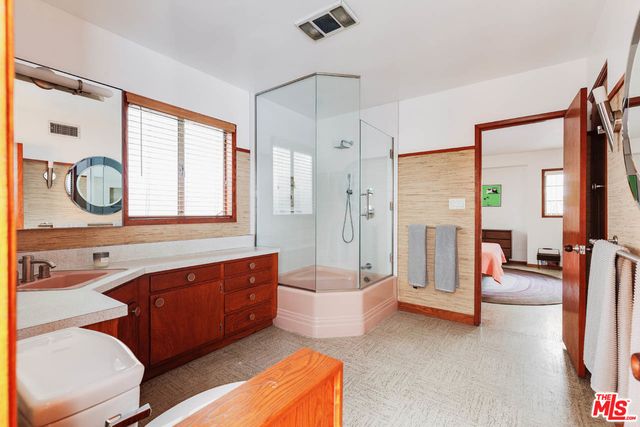 a spacious bathroom with a double vanity sink a large mirror and a bathtub