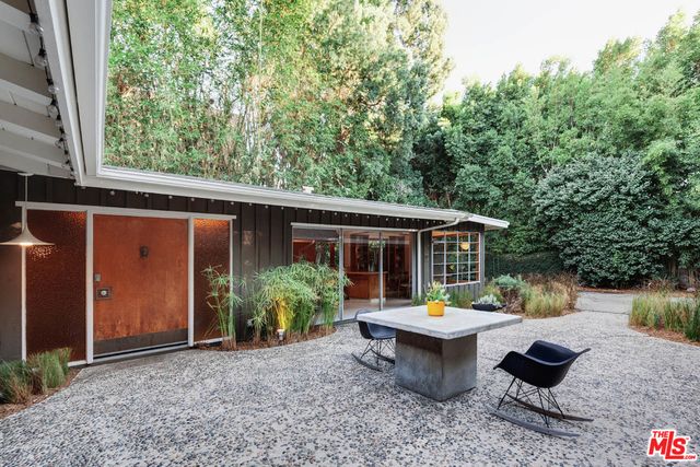a view of a backyard with sitting area and garden