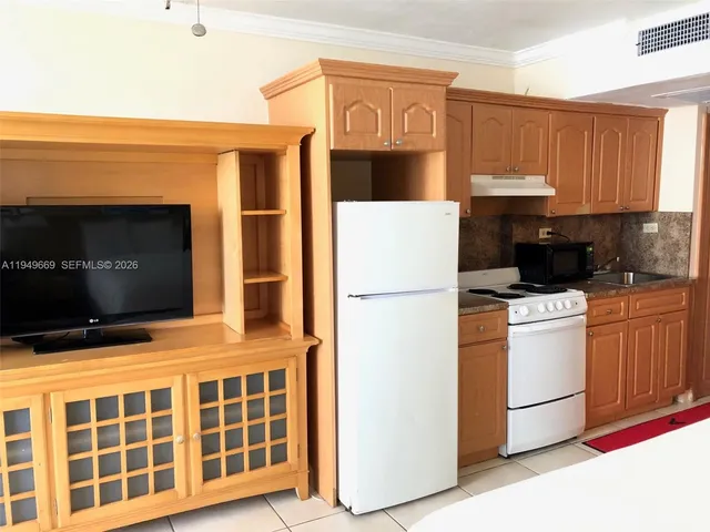 a kitchen with stainless steel appliances a stove a microwave and wood cabinets