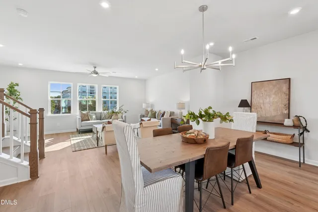 a kitchen with kitchen island a dining table chairs and white cabinets