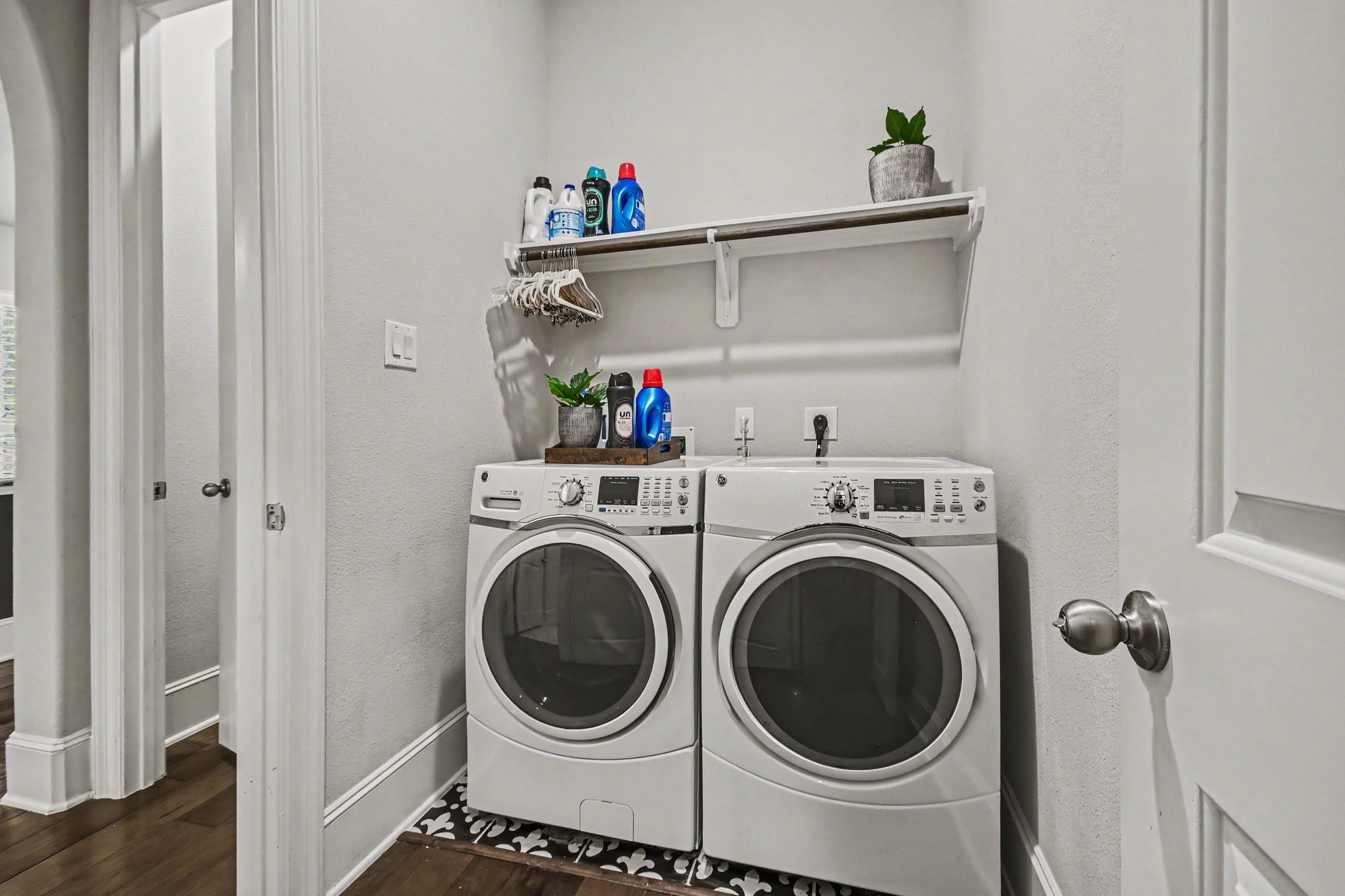 641 Kickapoo Court Webster, TX 77598 - Photo 14 of 39 Your functional laundry area, this utility room has both gas and electric dryer hookups. It includes a shelf above for storage, perfect for organizing laundry supplies. The space has a clean, practical design.