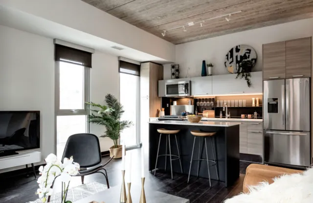 a kitchen with granite countertop a table chairs refrigerator and microwave