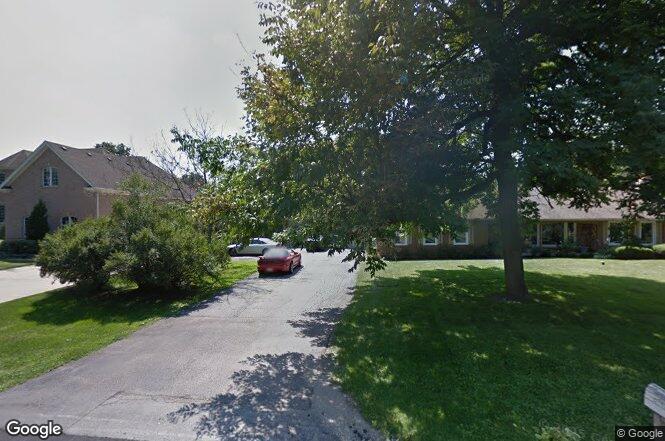 a view of a backyard with couches plants and large trees