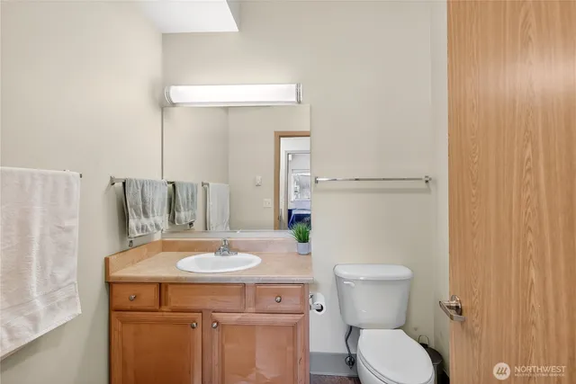 a bathroom with a sink a toilet a mirror and shower