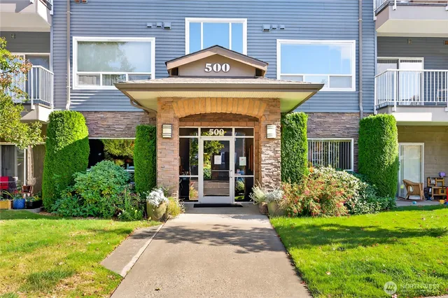 a view of a house with brick walls and a yard with plants