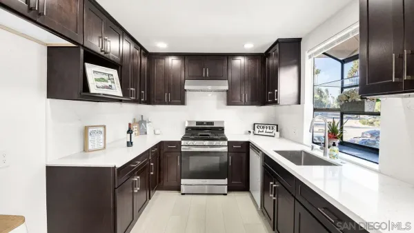 a kitchen with stainless steel appliances granite countertop a sink stove and refrigerator