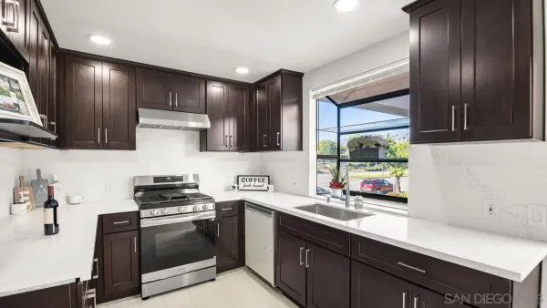 a kitchen with stainless steel appliances a sink stove and cabinets
