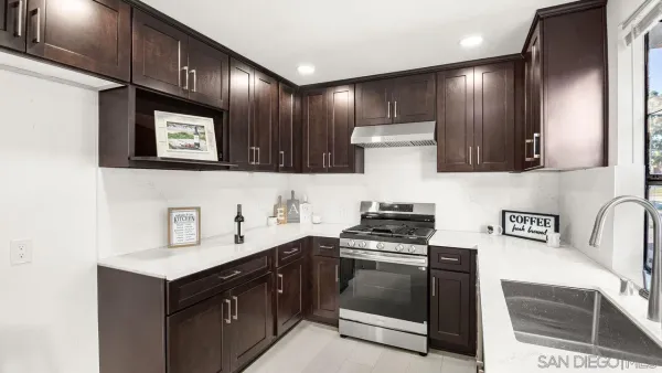 a kitchen with stainless steel appliances a sink stove and cabinets
