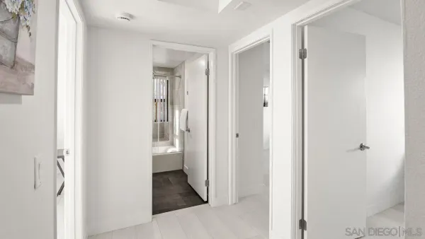 a view of a hallway with wooden floor and closet