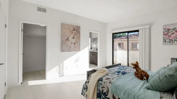 a bedroom with a large bed and a painting on the wall